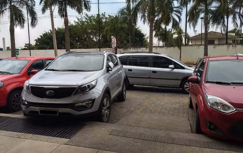 A motorista do Kia Sportage (E) estacionou seu carro em cima da vaga para cadeirantes, atrapalhando a vida de um casal que precisava da vaga